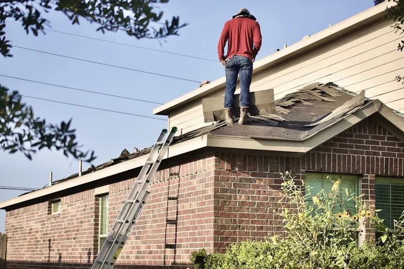 Professional roofer working on a residential roof in Westhampton